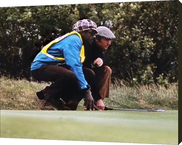 Gary Player and his caddy line up a putt at the 1974 Open