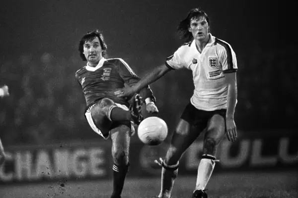 George Best passes the ball as he is challenged by Glenn Hoddle