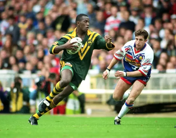 Wendell Sailor (Aus) carries the ball as Jonathan Davies (GB) looks on