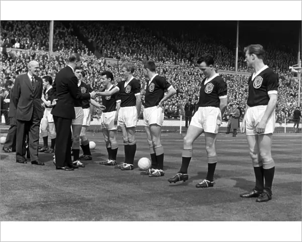 Prince Phillip shakes hands with Denis Law during the 1961 Home Championship