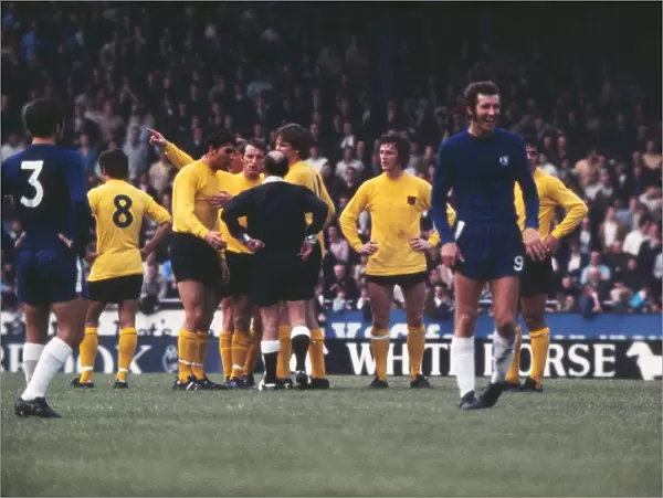 Peter Osgood laughs as Ipswich players appeal to the referee
