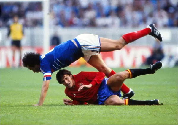 Frances Michel Platini is tackled by Spains Victor Munoz in the final of Euro 84