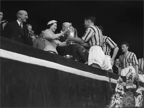 Aston Villa captain Johnny Dixon receives the FA Cup from the Queen in 1957