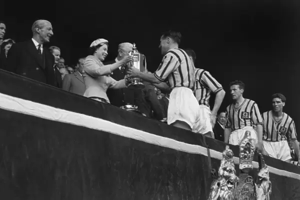 Aston Villa captain Johnny Dixon receives the FA Cup from the Queen in 1957