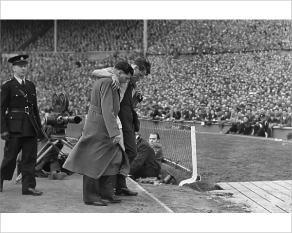 Manchester Citys Jimmy Meadows leaves the field with a knee injury in the 1955 FA Cup Final
