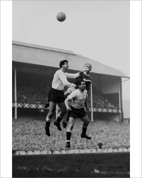 Dave Mackay and Maurice Norman jump for Spurs against Evertons Alex Young