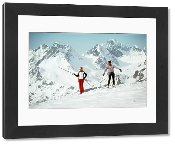 Two Skiers admire the view from a mountain top