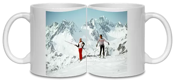 Two Skiers admire the view from a mountain top