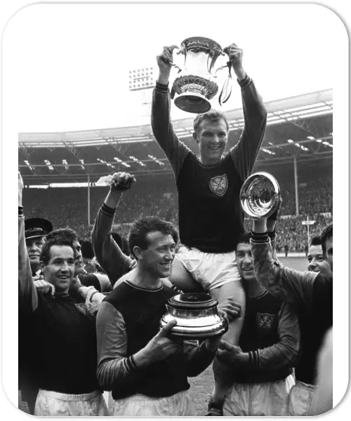 West Ham captain Bobby Moore lifts the FA Cup trophy in 1964