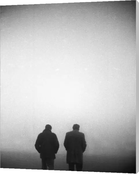 England manager Don Revie and FA Secretary Ted Coker walk off the pitch in the fog after the game against Czechoslovakia is abandoned in 1975