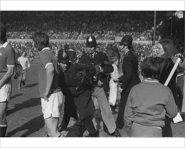 Police arrest Manchester United fans invading the Old Trafford pitch in 1974