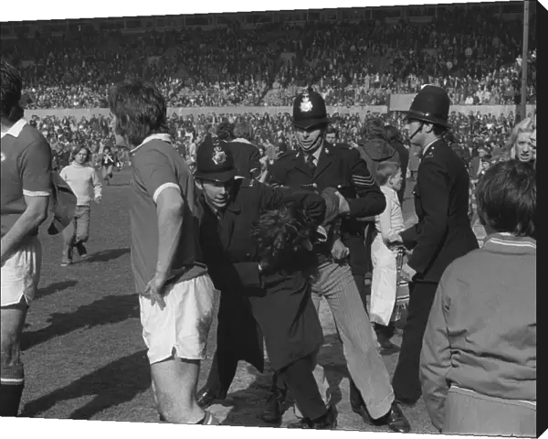 Police arrest Manchester United fans invading the Old Trafford pitch in 1974