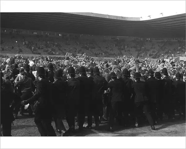 Police try to stop Manchester United fans invading the Old Trafford pitch after Denis Laws goal relegates the club in 1974