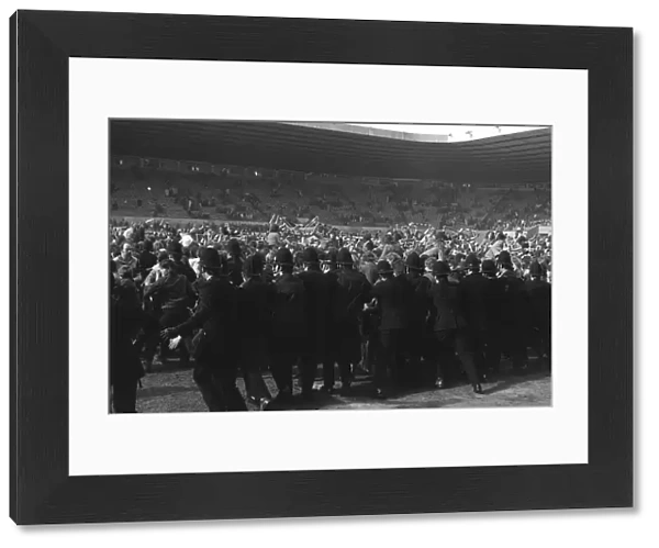Police try to stop Manchester United fans invading the Old Trafford pitch after Denis Laws goal relegates the club in 1974
