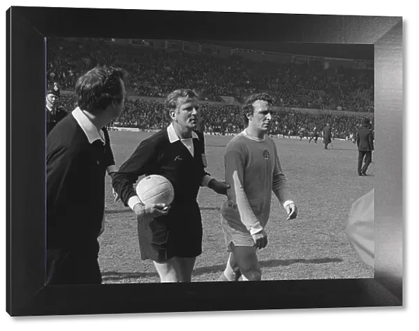 Manchester Citys Mike Summerbee is escorted off the pitch after Manchester United fans invade the field in 1974