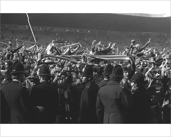 Manchester United fans invade the Old Trafford pitch after Denis Laws goal for Manchester City in 1974