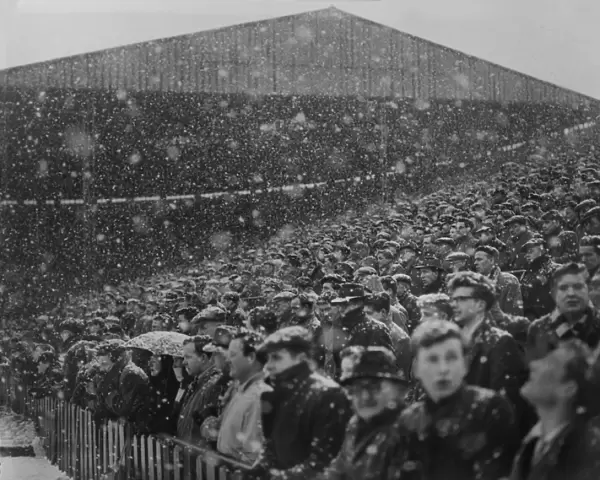 Fans at Old Trafford watch the action in the snow during the 1954  /  5 FA Cup