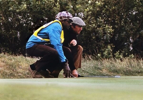 Gary Player and his caddy line up a putt at the 1974 Open