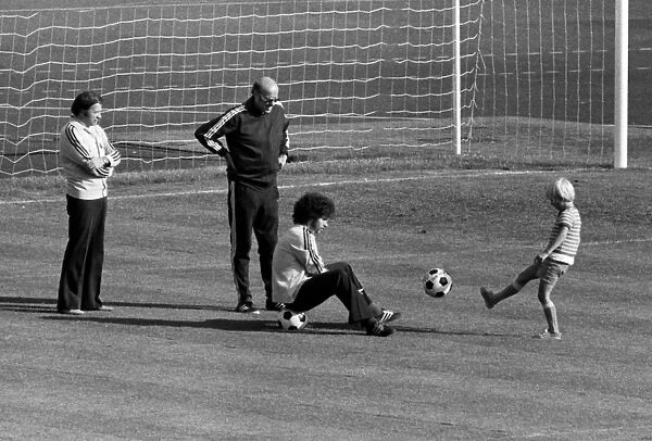 Paul Breitner sits on a ball with Helmut Schoen after West Germany training - 1974 World Cup