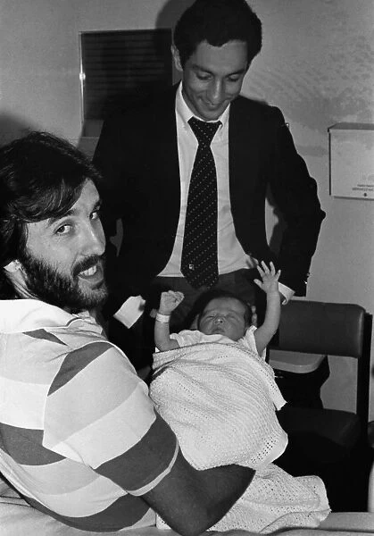 Ricky Villa holds his new baby, as Tottenham team mate Ossie Ardiles comes to visit the child at Chase Farm Hospital, Enfield
