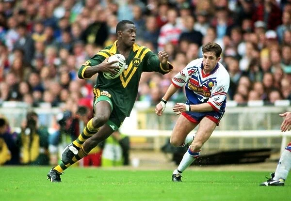 Wendell Sailor (Aus) carries the ball as Jonathan Davies (GB) looks on