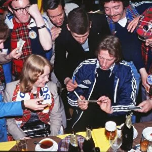 Denis Law signs autographs for Scottish fans at a bar at the 1978 World Cup