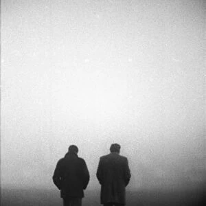 England manager Don Revie and FA Secretary Ted Coker walk off the pitch in the fog after the game against Czechoslovakia is abandoned in 1975