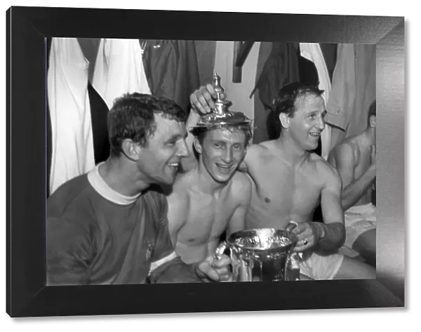 Bobby Charlton has a cigarette as his teammates celebrate after winning the FA Cup