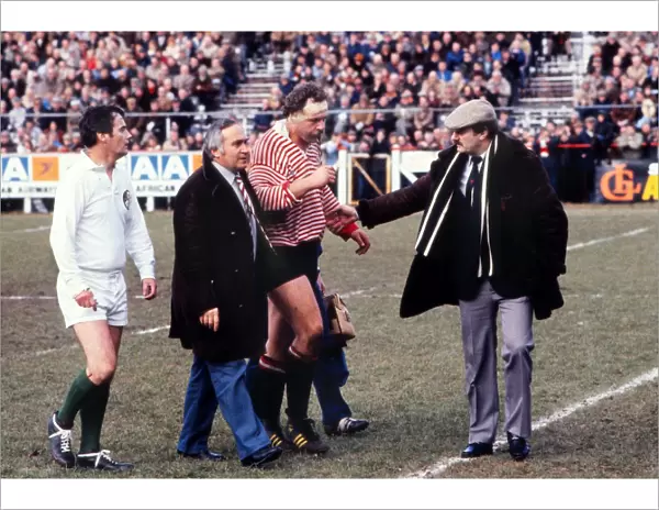 Bill Beaumont is helped from the field during his last ever match in 1982
