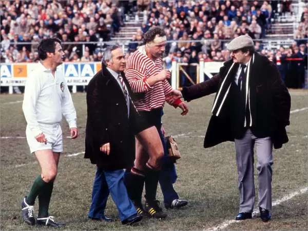 Bill Beaumont is helped from the field during his last ever match in 1982