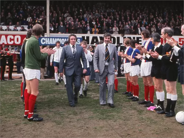 Dave Mackay and Des Anderson are applauded onto the field as they lead out their title-winning Derby County side at the Baseball Ground in 1975