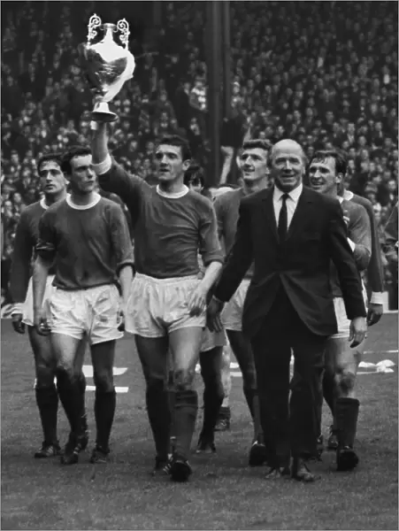 Bill Foulkes holds aloft the trophy alonside Matt Busby as the title-winning Manchester United team do a lap of honour in 1967