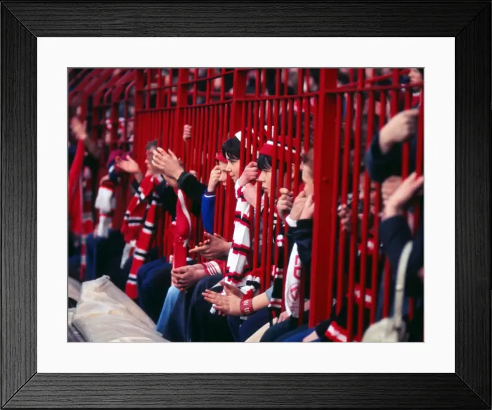 Framed Print : Manchester United fans hold their scarves through fences at the Stretford End in 1977 Framed Print : Manchester United fans hold their scarves through fences at the Stretford End in 1977