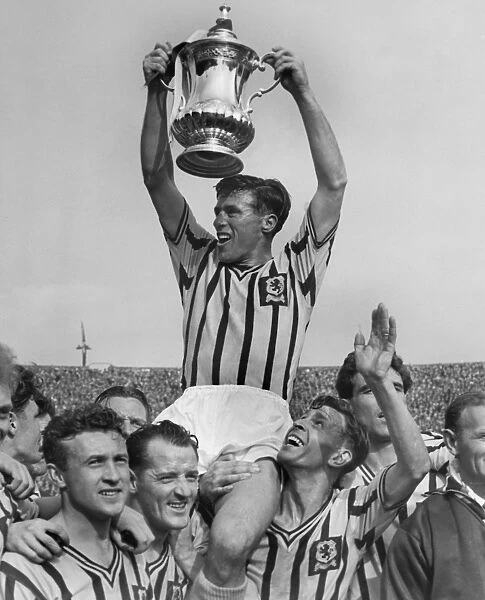 Aston Villa captain Johnny Dixon lifts the FA Cup in 1957