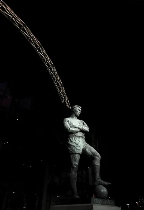 Framed Print : The Bobby Moore statue stands in front of an illuminated Wembley Stadium Framed Print : The Bobby Moore statue stands in front of an illuminated Wembley Stadium