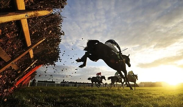 The riders clear the last hurdle of the 15: 05 Stan James International Hurdle at Cheltenham racecourse