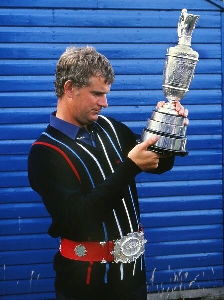 Sandy Lyle examines the Claret Jug while wearing a replica of the original Championship Belt in 1985