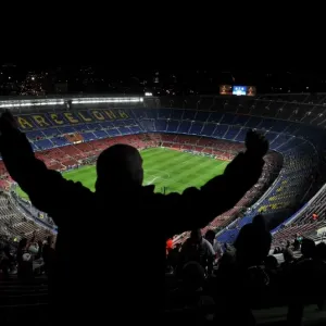An Arsenal fan sings and dances in the top tier of the Nou Camp before the game against Barcelona
