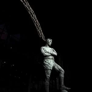 The Bobby Moore statue stands in front of an illuminated Wembley Stadium