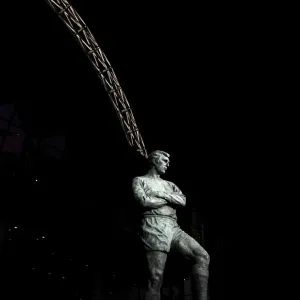 The Bobby Moore statue stands in front of an illuminated Wembley Stadium