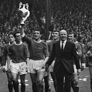Bill Foulkes holds aloft the trophy alonside Matt Busby as the title-winning Manchester United team do a lap of honour in 1967