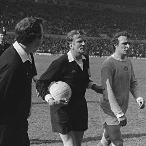 Manchester Citys Mike Summerbee is escorted off the pitch after Manchester United fans invade the field in 1974