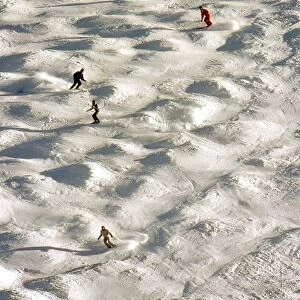Skiers negotiate a mogul field in Tignes, France in December 1987