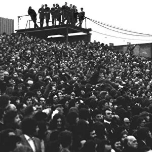 A young fan is passed over the heads of fans in the Clock End at Highbury during the 1973 FA Cup
