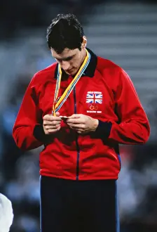 Allan Wells inspects his 100m gold medal on the podium at the 1980 Moscow Olympics