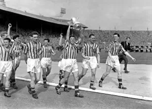1957 FA Cup Final - Aston Villa 2 Manchester United 1 Collection: Aston Villa captain Johnny Dixon leads his side on a victory lap with the FA Cup trophy in 1957
