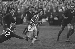 A bloodied JPR Williams runs for Bridgend against the All Blacks in 1978