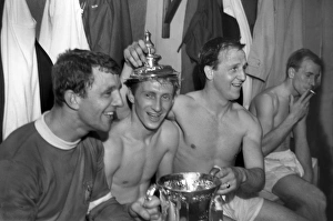 Bobby Charlton has a cigarette as his teammates celebrate after winning the FA Cup