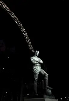 The Bobby Moore statue stands in front of an illuminated Wembley Stadium