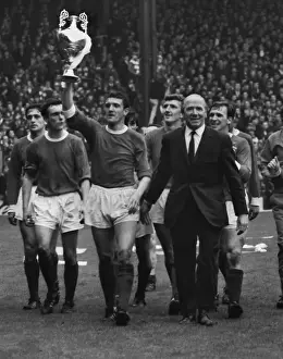 Bill Foulkes holds aloft the trophy alonside Matt Busby as the title-winning Manchester United team do a lap of honour in 1967